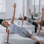 Frauen in Yoga-Position in Trainingsraum